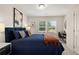 Bedroom featuring a workspace, large windows, and a comfortable blue quilt on the bed at 549 Tuskegee St, Mcdonough, GA 30253