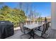 Back deck with a table and chairs surrounded by lush trees offers an excellent space for entertaining guests at 2785 Old Sewell Rd, Marietta, GA 30068