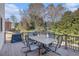 Back deck with a table and chairs surrounded by lush trees offers an excellent space for entertaining guests at 2785 Old Sewell Rd, Marietta, GA 30068