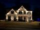 Elegant exterior view of a brick home with striking lighting enhancing its architectural details at night at 2785 Old Sewell Rd, Marietta, GA 30068