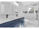 Bright bathroom featuring a double sink vanity with blue cabinets and white marble countertops, plus a shower and tub at 353 Old Rosser Rd, Stone Mountain, GA 30087