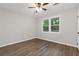 This bedroom features light gray walls, a ceiling fan, hardwood floors and a double hung window at 612 Saddlewood Dr, Lawrenceville, GA 30043