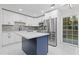 Modern kitchen featuring stainless steel appliances, white cabinets, and a blue island with a white countertop at 612 Saddlewood Dr, Lawrenceville, GA 30043