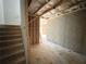 Unfinished basement area with stairs leading up, concrete foundation, and wooden framing at 66 Pine Creek Ct, Dallas, GA 30157