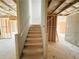 Unfinished basement with a staircase leading to potential living space with framed walls at 66 Pine Creek Ct, Dallas, GA 30157