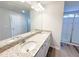 Bathroom featuring a double sink vanity with granite counters, white cabinets, and a glass-enclosed shower at 66 Pine Creek Ct, Dallas, GA 30157