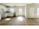 Bright, unfinished kitchen with white cabinets, gray countertops, and natural light at 66 Pine Creek Ct, Dallas, GA 30157