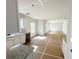 Bright open-concept living area featuring white walls connecting to an unfinished kitchen with granite countertops at 66 Pine Creek Ct, Dallas, GA 30157