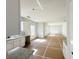 Bright open-concept living area featuring white walls connecting to an unfinished kitchen with granite countertops at 66 Pine Creek Ct, Dallas, GA 30157