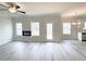 Bright living room featuring modern fireplace, fan, and gray wood-look flooring at 66 Pine Creek Ct, Dallas, GA 30157