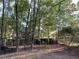 Landscaped backyard with mature trees and a wood pile ready for use at 1504 Sycamore Nw Dr, Kennesaw, GA 30152