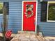 Eye-catching red front door, adorned with a wreath, welcomes you to your new home at 1504 Sycamore Nw Dr, Kennesaw, GA 30152