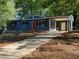 Charming blue home featuring a long driveway, red front door, and a covered carport at 1504 Sycamore Nw Dr, Kennesaw, GA 30152