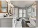 Bright bathroom features double vanity, freestanding tub, glass enclosed shower, and dark tile floors at 764 Whitby Dr, Douglasville, GA 30134