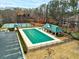 A community pool and tennis court are surrounded by trees and a green lawn, offering a tranquil escape for residents at 764 Whitby Dr, Douglasville, GA 30134