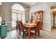 Elegant dining room featuring a wooden table, large window, and decorative china cabinet at 764 Whitby Dr, Douglasville, GA 30134