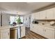 Open kitchen featuring white cabinets, stainless steel appliances, and wood-look flooring at 764 Whitby Dr, Douglasville, GA 30134
