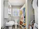 Bathroom with a pedestal sink, toilet, and shower with colorful curtain at 105 Huskins Rd, Canton, GA 30115