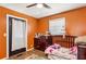 Bright bedroom with a crib and warm orange walls and wood floors at 105 Huskins Rd, Canton, GA 30115