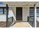 Front porch with a black front door and railing, set against a white brick exterior at 105 Huskins Rd, Canton, GA 30115