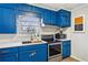 Bright kitchen with blue cabinets, gold hardware, and stainless steel appliances at 105 Huskins Rd, Canton, GA 30115