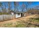 Rear exterior of this cozy home showcasing a fenced yard and a glimpse of the neighborhood at 105 Huskins Rd, Canton, GA 30115