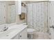 Bright bathroom features a white vanity and a shower-tub combo with a stylish fern-patterned curtain at 1270 Platinum Dr, Hoschton, GA 30548