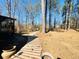 A serene backyard featuring a wood pathway in a treed landscape for a peaceful outdoor retreat at 4665 Guilford Forest Sw Dr, Atlanta, GA 30331