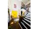 Foyer with decorative staircase, stylish rug, and bright yellow door at 4665 Guilford Forest Sw Dr, Atlanta, GA 30331