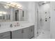 Bathroom featuring sleek vanity with quartz countertop and glass shower with marble-style tiling at 47 Cuthbert Ln Ne, Acworth, GA 30101