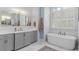 Bathroom with white marble floors, quartz countertops and free standing bathtub under a window at 47 Cuthbert Ln Ne, Acworth, GA 30101