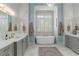 Bathroom with white marble floors, quartz countertops and bathtub under a window at 47 Cuthbert Ln Ne, Acworth, GA 30101