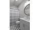 Charming bathroom with black and white tiled floor, a round mirror, and a shower with a striped curtain at 47 Cuthbert Ln Ne, Acworth, GA 30101