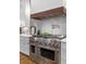 Modern kitchen featuring stainless steel range with custom wood hood and gray tile backsplash at 47 Cuthbert Ln Ne, Acworth, GA 30101