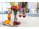 Kitchen island featuring quartz countertop, bottle of wine, bouquet of flowers, glasses of wine, grapes, and assorted cheese and crackers at 47 Cuthbert Ln Ne, Acworth, GA 30101