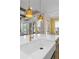 Kitchen island with quartz countertop, gold pendant lighting, and a farmhouse sink with gold colored faucet and fixtures at 47 Cuthbert Ln Ne, Acworth, GA 30101