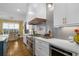 Modern kitchen features custom hood and stainless steel range, white cabinets, and open concept view of dining area at 47 Cuthbert Ln Ne, Acworth, GA 30101