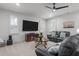 Spacious living room boasts a large TV, comfortable leather sofas, ceiling fan, and natural light from the window at 47 Cuthbert Ln Ne, Acworth, GA 30101