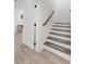 Bright staircase with modern wood and carpeted steps, next to a white door and light-colored hardwood floors at 47 Cuthbert Ln Ne, Acworth, GA 30101