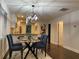 Dining area features a glass table, modern chandelier, and a view of the updated kitchen with a breakfast bar at 280 Spellman Nw St, Atlanta, GA 30314