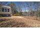 Backyard view of a home, featuring a spacious lawn and glimpses of a tranquil lake in the background at 3423 Conley Downs Drive, Powder Springs, GA 30127