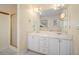 Bathroom featuring double sinks, large mirror, and glass enclosed shower at 3423 Conley Downs Drive, Powder Springs, GA 30127