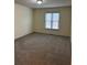 Neutral bedroom with plush carpeting and a large double-hung window overlooks the home's backyard at 3423 Conley Downs Drive, Powder Springs, GA 30127