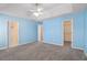 Spacious bedroom featuring plush carpeting, a ceiling fan, and ensuite bath and closet access at 3423 Conley Downs Drive, Powder Springs, GA 30127