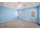 Bedroom featuring neutral blue walls, plush carpeting, and natural light from two windows at 3423 Conley Downs Drive, Powder Springs, GA 30127