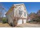 Side view of a two-story home with a two-car garage, showcasing its architecture and well-maintained exterior at 3423 Conley Downs Drive, Powder Springs, GA 30127