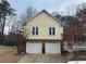 Two-story home featuring a yellow exterior, brick foundation, two-car garage and double-hung windows at 3423 Conley Downs Drive, Powder Springs, GA 30127