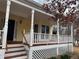 Charming covered front porch with white railings, turned posts, stained steps, and a black front door at 3423 Conley Downs Drive, Powder Springs, GA 30127