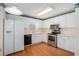 Well-lit kitchen with hardwood floors, white cabinets, and stainless-steel appliances at 3423 Conley Downs Drive, Powder Springs, GA 30127