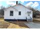 Rear view of the house featuring a white exterior, gray accents, and a concrete back patio at 5091 Newark Ave, Clarkdale, GA 30111